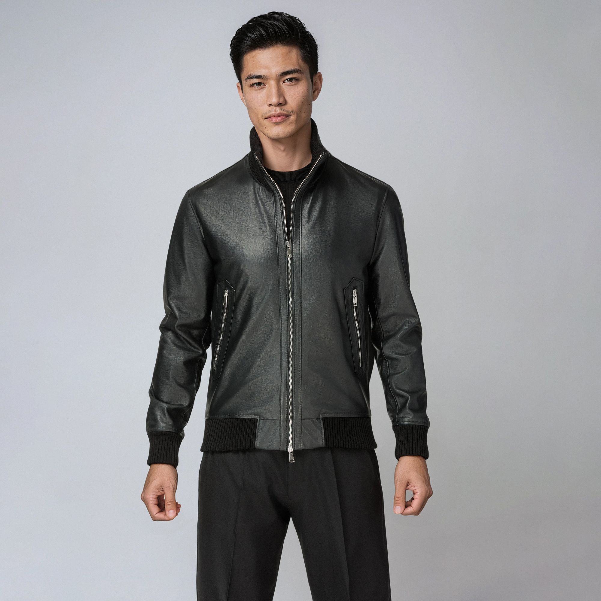 Άνδρας με total black look Elio Evan: μαύρο leather bomber jacket και μαύρο παντελόνι.