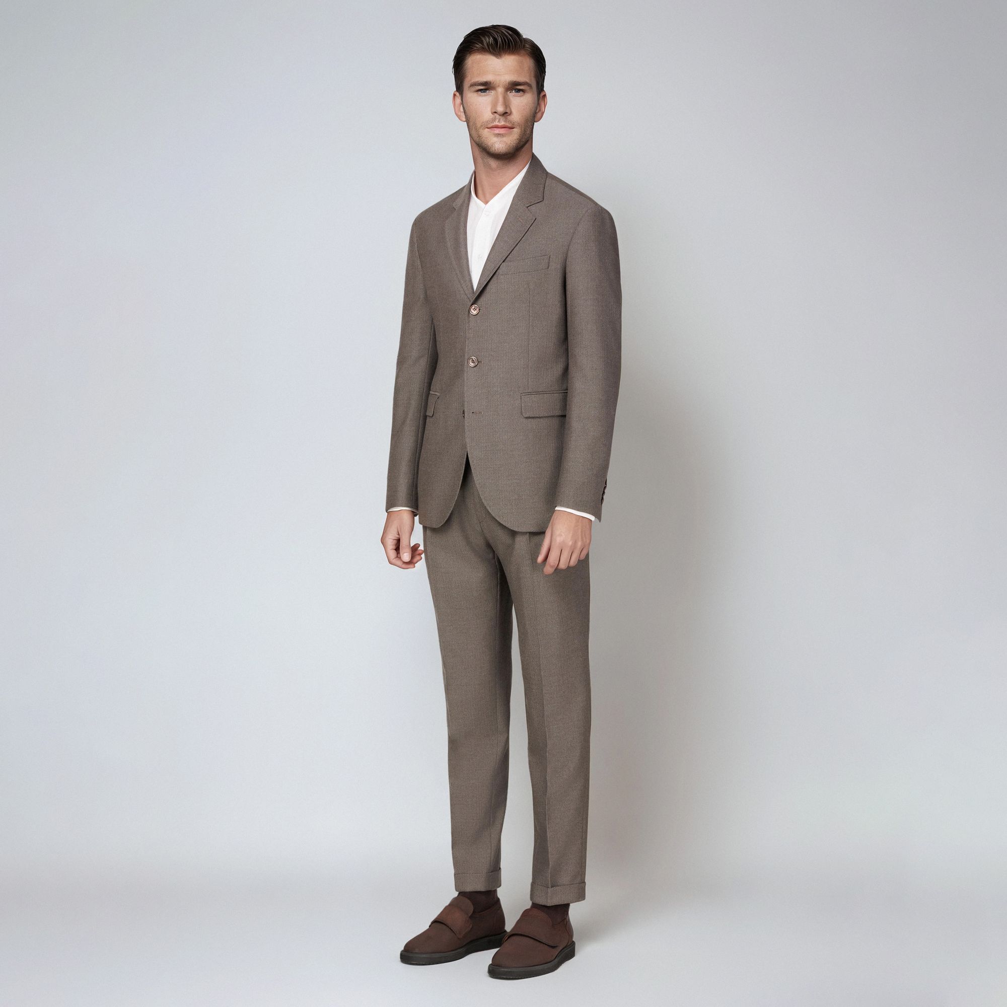 Άνδρας με total look Elio Evan: γκρεζ μάλλινο ανδρικό κοστούμι σε σχέδιο νψαροκόκκαλο, λευκό πουκάμισο – κομψή semi-formal και business εμφάνιση.